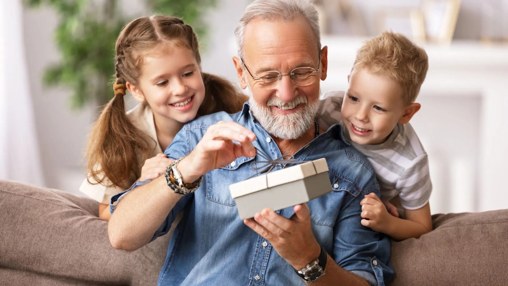 Grandchildren sharing a gift with their grandfather