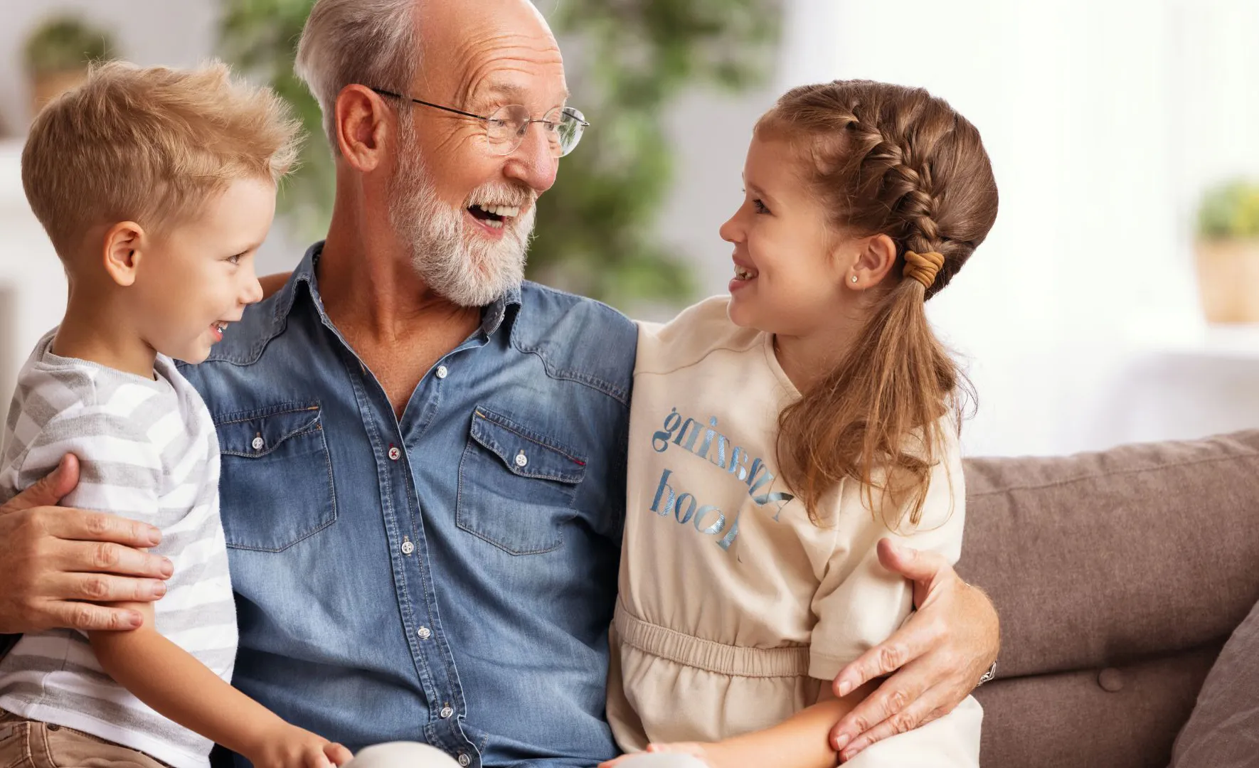 A grandfather laughing with his two grandchildren